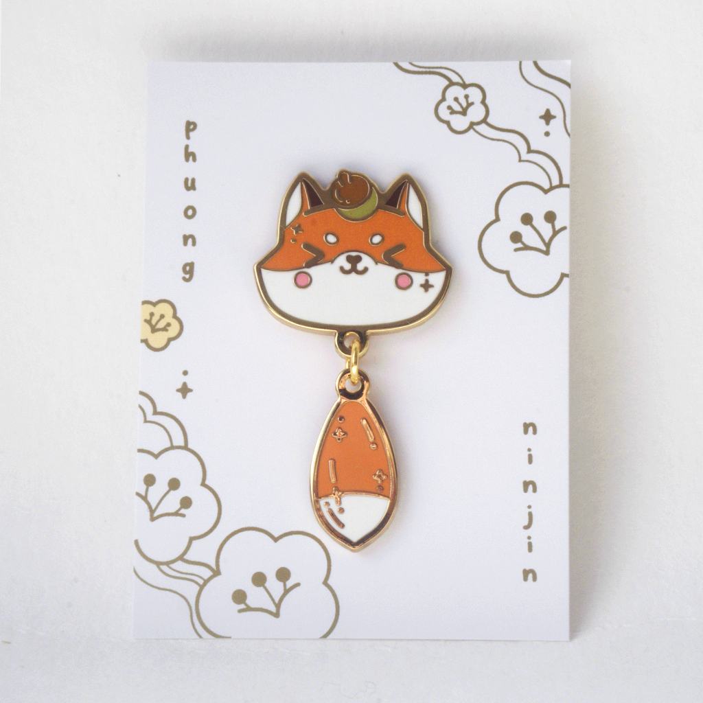 Fox enamel pin with golden outlines. Displayed here on the back card.
