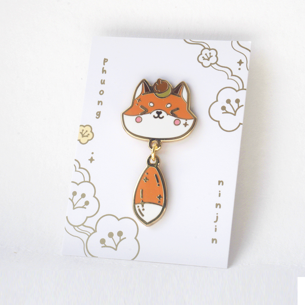 Fox enamel pin with golden outlines. Displayed here on the back card.