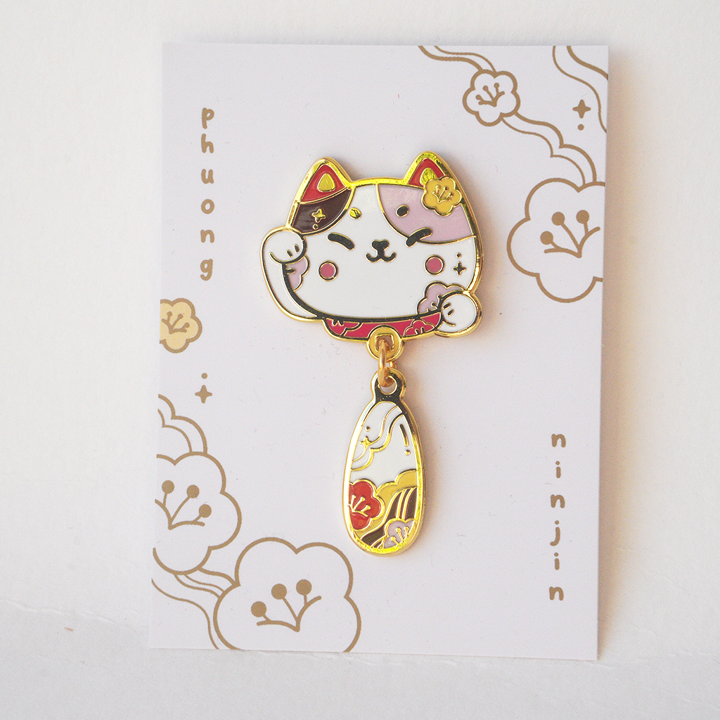 Lucky Lunar cat enamel pin displayed on our back card.