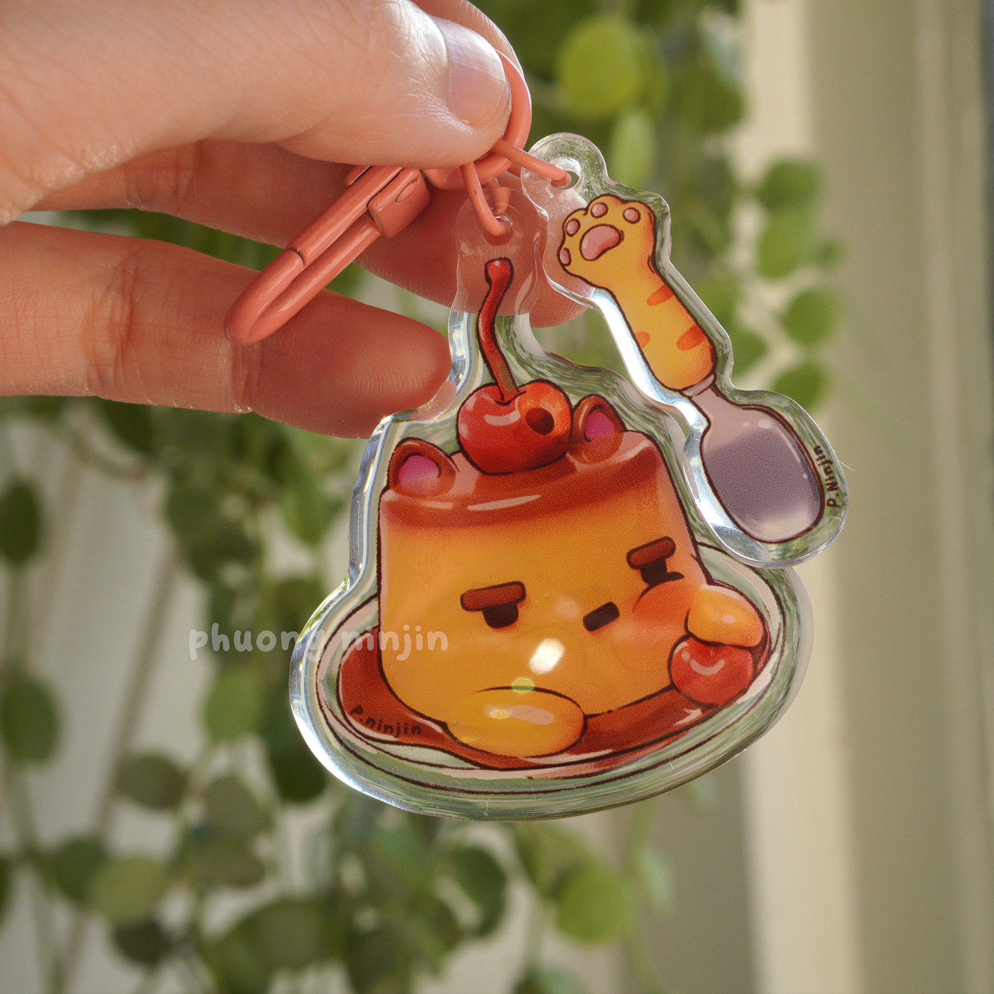 Dual sided flan keychain with cat ears and cherry on top. Along side a cat paw spoon. This side is showing the tooth ace side.