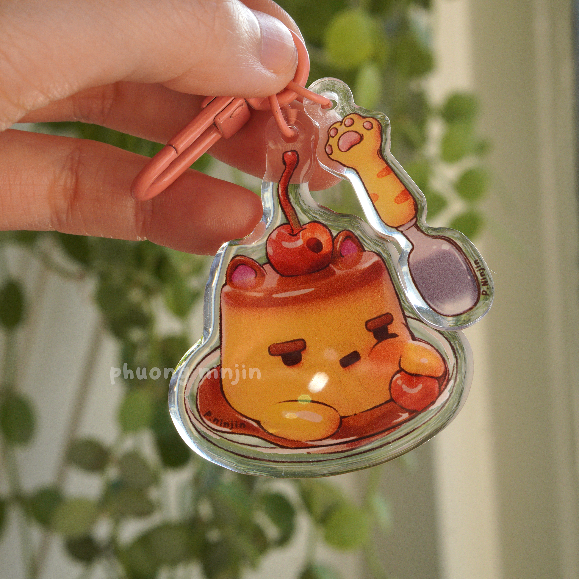 Dual sided flan keychain with cat ears and cherry on top. Along side a cat paw spoon. This side is showing the tooth ace side.