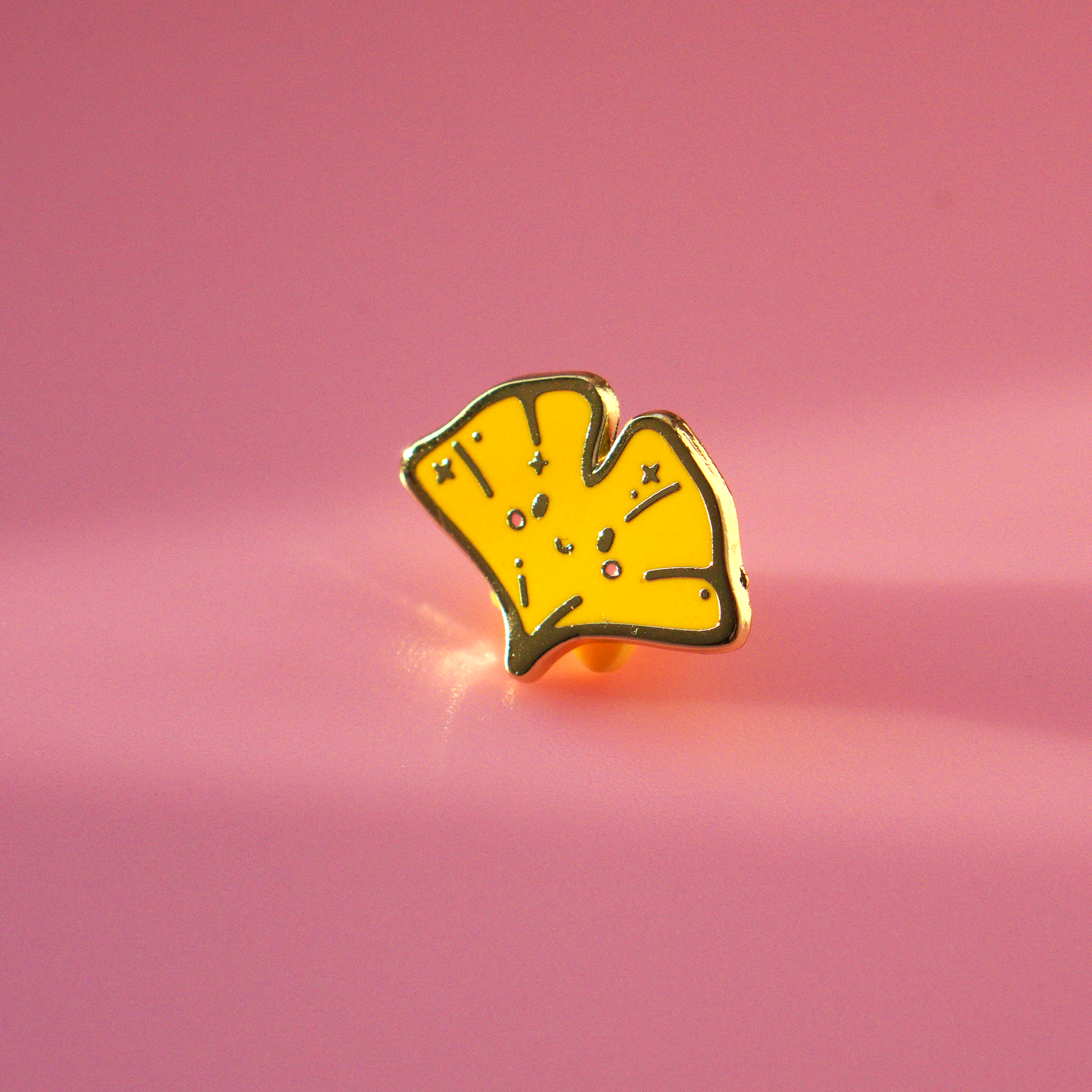 Ginkgo enamel pin with golden edge.