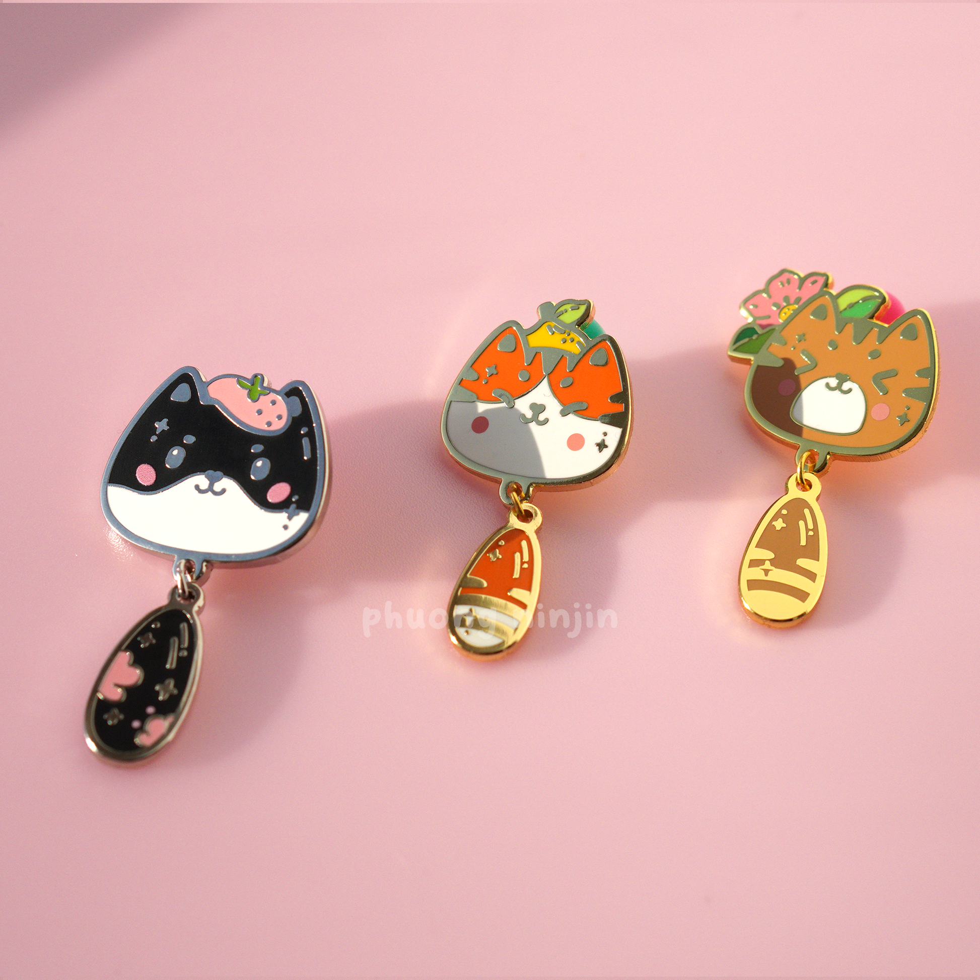 Mira cat enamel pin with silver edges displayed next to our Yuzu cat enamel pin, and momo cat enamel pin