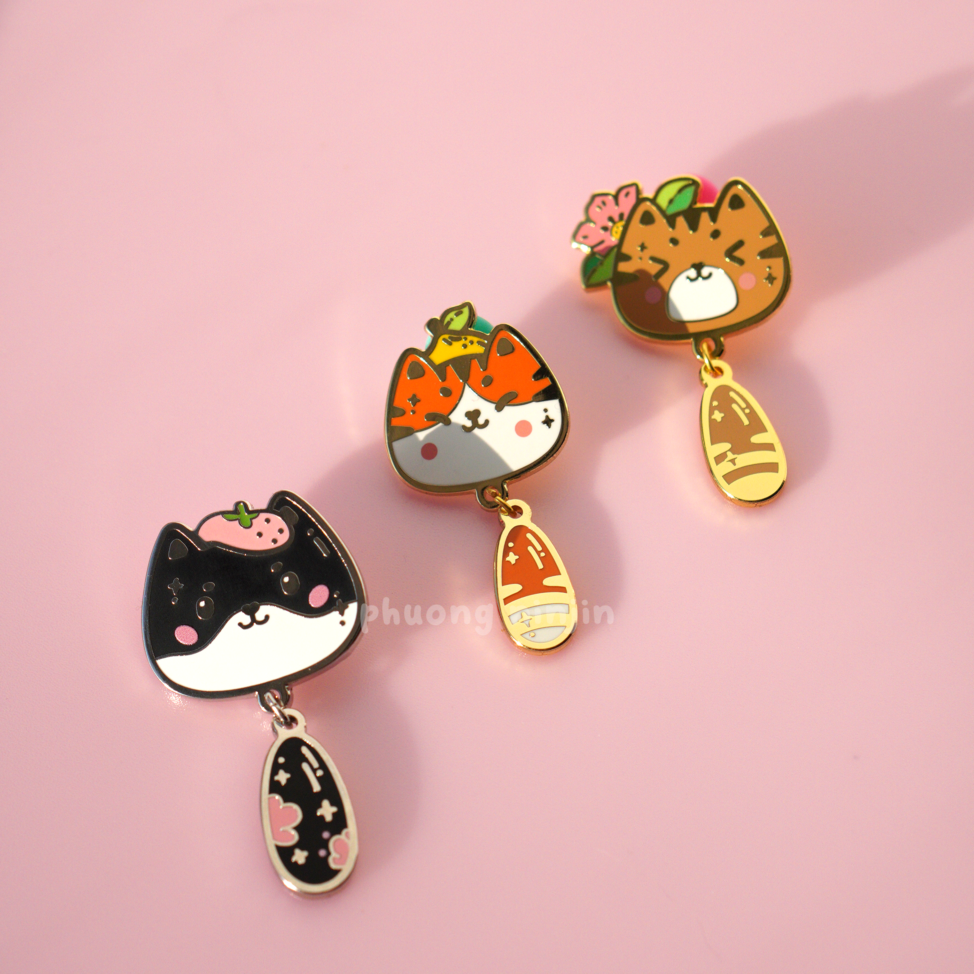 Mira cat enamel pin with silver edges displayed next to our Yuzu cat enamel pin, and momo cat enamel pin