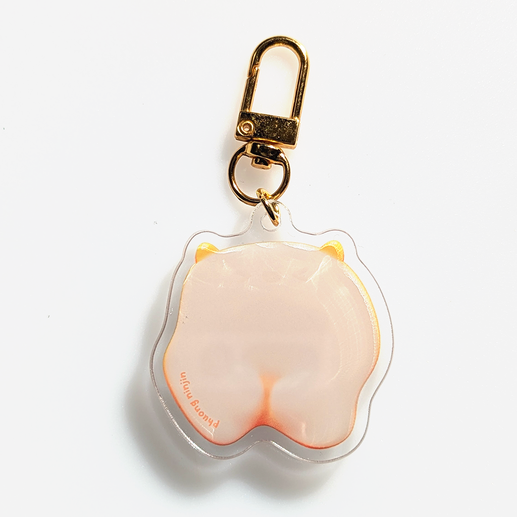 Egg keychain with >.< face and cute cat ears. The keychain has a 3D yolk. And Golden clamp. Shown here is the back with the Phuong Ninjin logo and butt cheeks