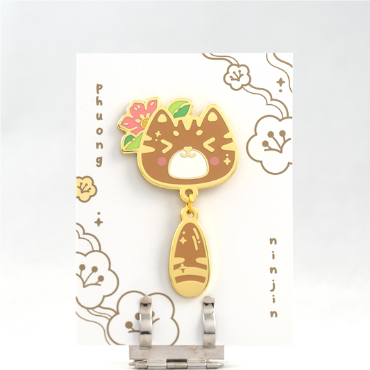 Momo cat enamel pin with golden edges. Displayed on our back card.